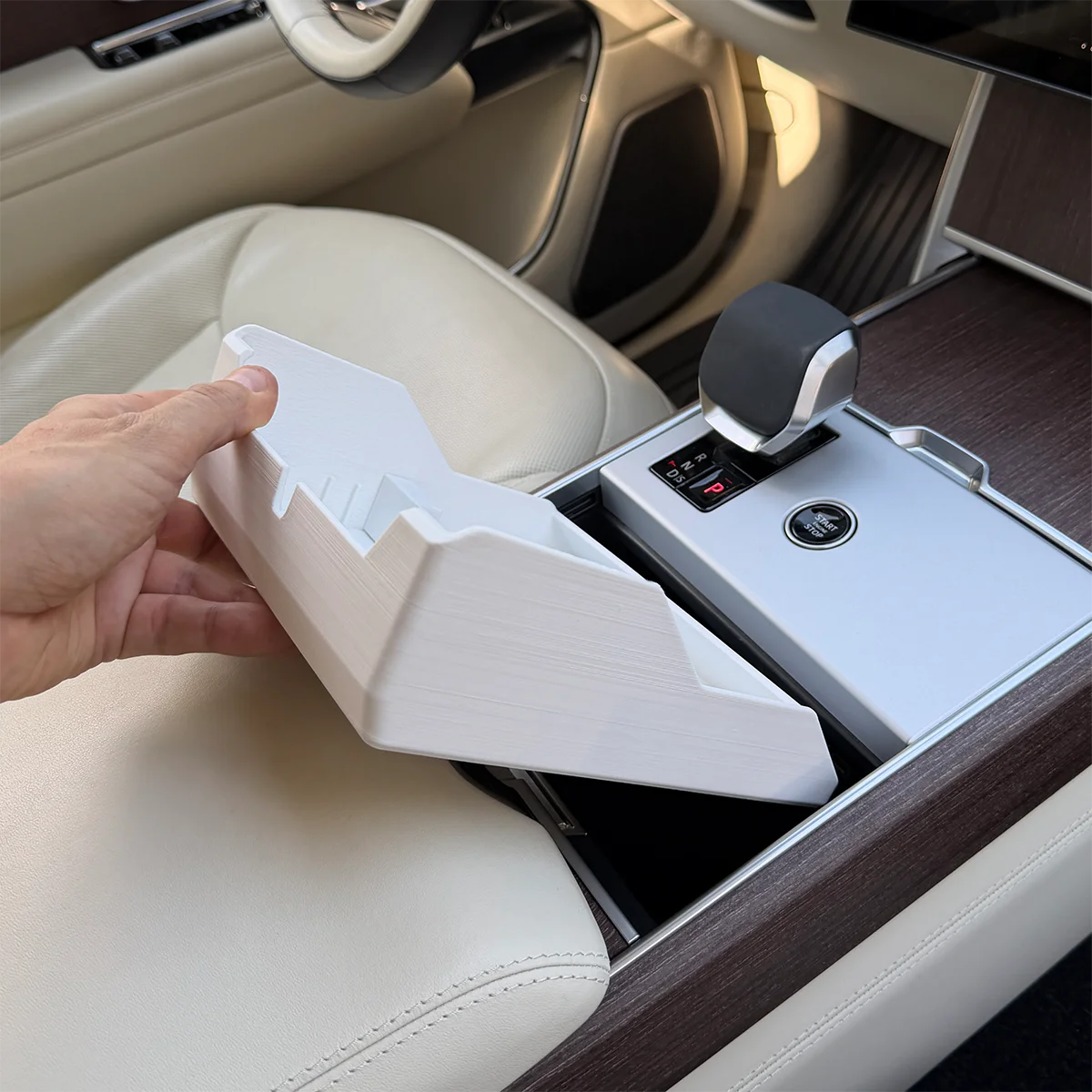 Range Rover Hidden Storage Organizer being lowered beneath the sliding cupholders