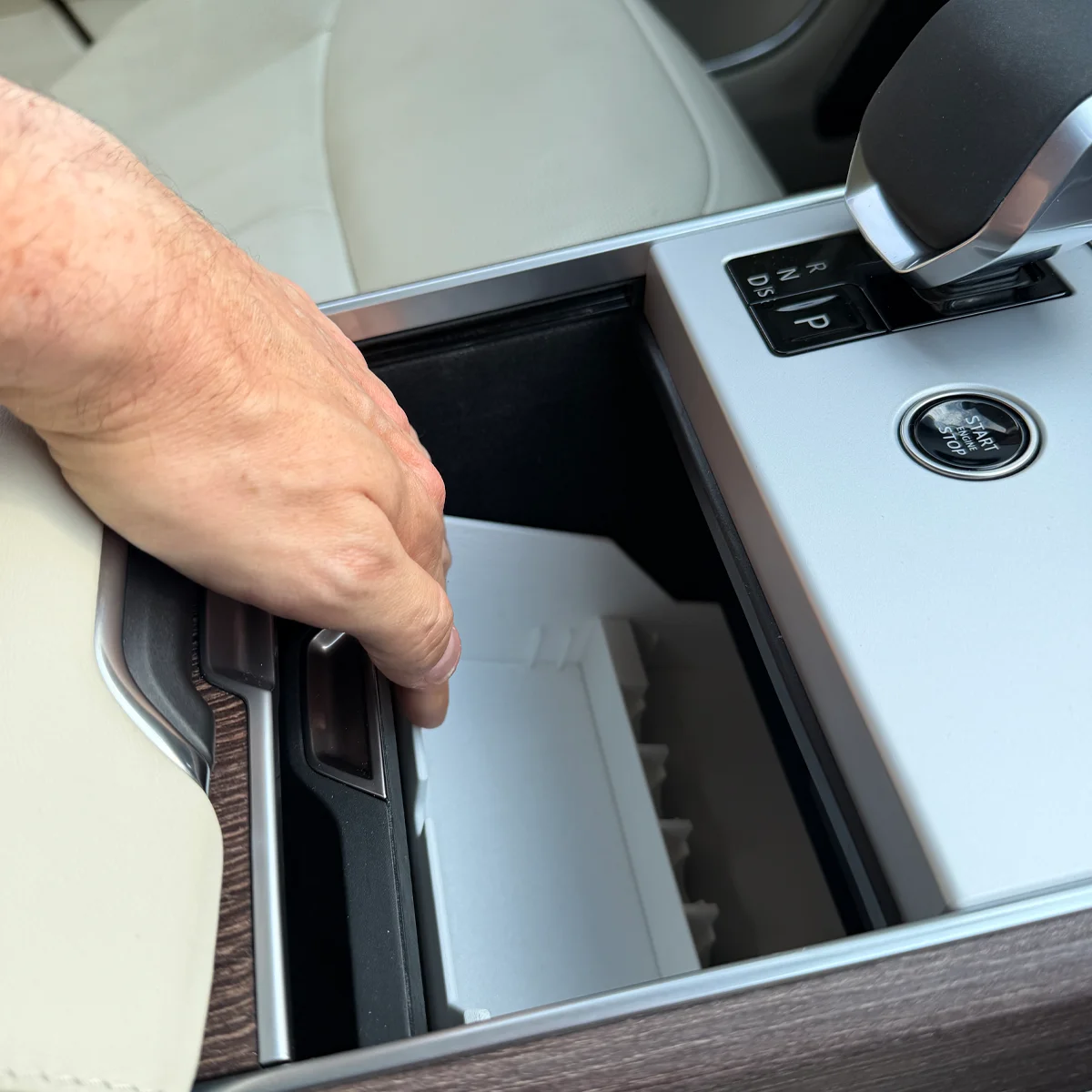 Pressing down at the rear of the Range Rover Hidden Storage Organizer